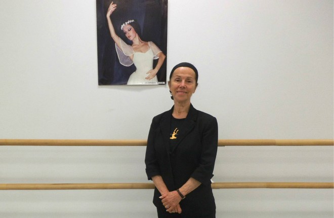 Jeunesse Classique Ballet Society's Founder & Artistic Director Umran Sumen, standing beside a portrait of herself from when she was a leading soloist with The National Ballet Company of Turkey.